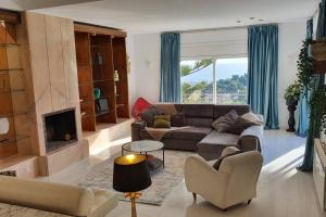 a living room with a couch and a fireplace at Opening Doors Premiá Dalt Amazing views w pool in Premia de Dalt
