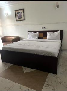 a bedroom with a large bed with white sheets and pillows at Savannah Suites in Gwarinpa