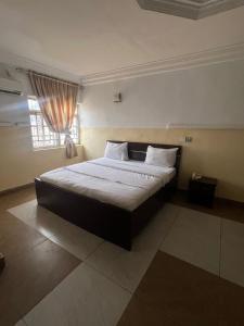 a large bed in a room with a window at Savannah Suites in Gwarinpa