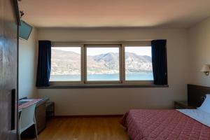 a bedroom with a bed and a large window at Locanda del Lago Rosmunda in Clusane sul Lago