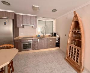 a kitchen with wooden cabinets and stainless steel appliances at Pasión Junto al mar in Calpe +9 photos