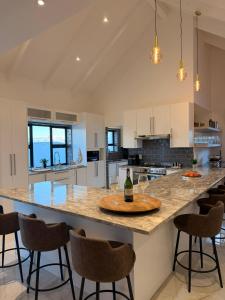 a kitchen with a large island with a table with wine glasses on it at Hermanus Villa in Hermanus