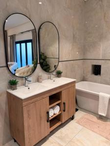 a bathroom with two sinks and a tub and a mirror at Hermanus Villa in Hermanus +36 photos