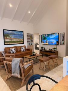 a living room with a couch and chairs and tables at Hermanus Villa in Hermanus