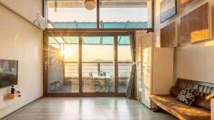 a living room with a large window and a couch at Sacheon Bichae Pension in Sacheon