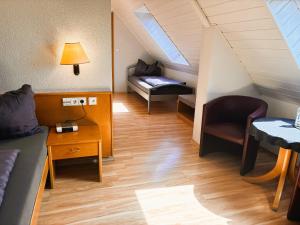 a room with a bed and a couch and a table at Hotel Garni KAMBEITZ in Ötigheim