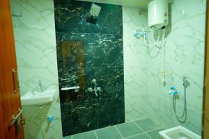 a bathroom with a black and white marble wall at The Casa Comforts in New Hampi