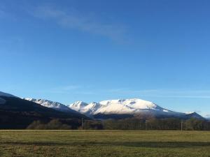 a snow covered mountain in the distance with a field at Robins Nest in Roybridge +4 photos