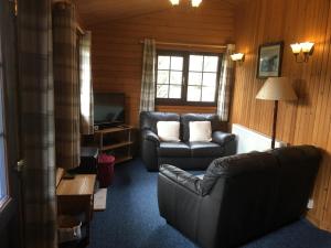 a living room with a couch and a chair and a television at Robins Nest in Roybridge