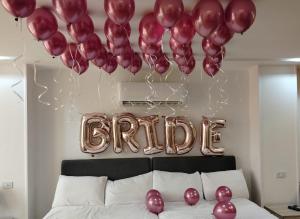 a bunch of balloons hanging above a bed with a sign that reads alpha at الحصرى Elhosary otel in 6th Of October