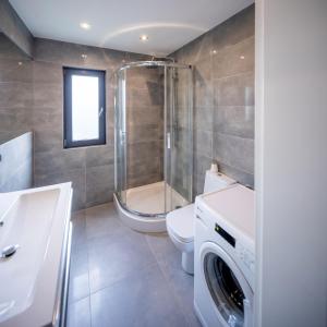 a bathroom with a shower toilet and a washing machine at LR10 Dom Wakacyjny in Lubogoszcz +20 photos