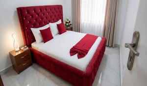 a bedroom with a large bed with a red headboard at Choice Lounge in Rubavu
