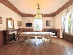a dining room with a table and chairs and a chandelier at L'instant champenois - all inclusive in Bréviandes
