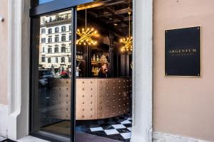 a window of a restaurant with a woman inside at Argentum Boutique Hotel & SPA in Rome