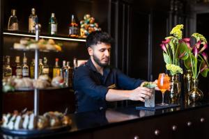 a man sitting at a bar with a drink at Argentum Boutique Hotel & SPA in Rome +45 photos