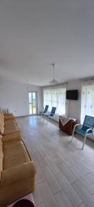 a living room with a couch and chairs and a flat screen tv at Casă Bubu in Cacica
