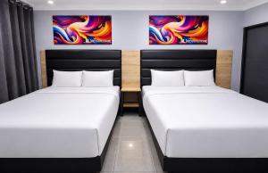 two beds in a room with paintings on the wall at Metro Lodge MP in Durban +16 photos