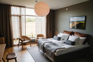 a bedroom with a large bed and a table and chairs at Barsebäck Resort Hotell in Löddeköpinge +33 photos
