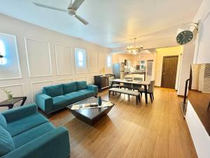 a living room with a blue couch and a table at 3BHK Elegant Duplex Villa with Pool Access in Assagao