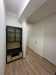 an empty room with a book shelf and a white wall at Sumgait Boulevard View Apartment in Sumqayıt