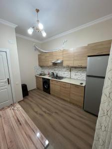 a large kitchen with wooden cabinets and a refrigerator at Sumgait Boulevard View Apartment in Sumqayıt