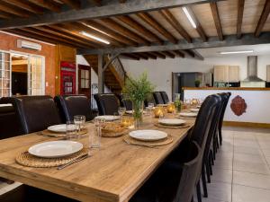 a long wooden table with black chairs around it at DOMAINE DE LA PORTE in Agonac