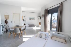 a white room with a bed and a table at Halari Junior Suite in Vourvoúlos +34 photos