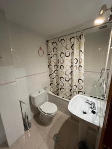 a white bathroom with a toilet and a sink at Hotel Carvajal in Torrejón el Rubio +58 photos