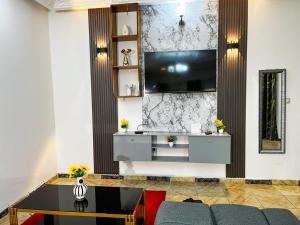 a living room with a television on a wall at Maridel Home in Yaoundé