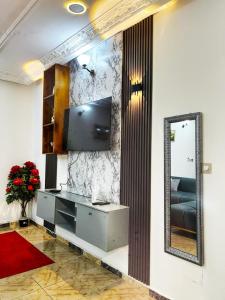 a living room with a mirror and a tv at Maridel Home in Yaoundé