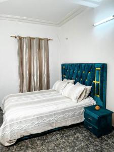 a bedroom with a large bed with a blue headboard at Maridel Home in Yaoundé