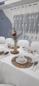 a table with white chairs and a white table with glasses at Hotel Carvajal in Torrejón el Rubio
