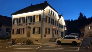 a white car parked in front of a building at Hôtel Von Bergen in La Sagne