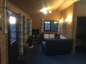a living room with a couch and a television at Rowantree View in Roybridge