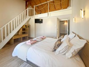a bedroom with a bed with white sheets and a staircase at DOMAINE DE LA PORTE in Agonac +28 photos