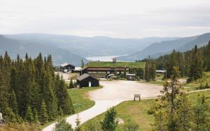 a building with a green roof on a mountain at Gudbrandsgard Hotel in Kvitfjell