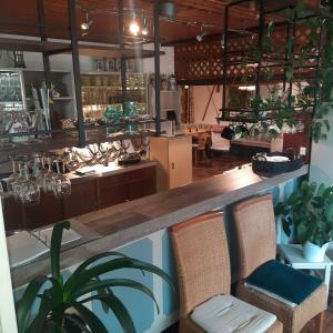 a restaurant with a bar with chairs and plants at Pension Hubertushöhe in Kulmbach +19 photos