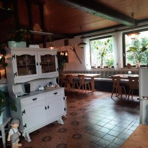 a kitchen and dining room with white cabinets and a table at Pension Hubertushöhe in Kulmbach