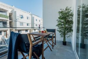 a table and chairs on a balcony with a plant at St Julians`s Boho Apartments in Is-Swieqi