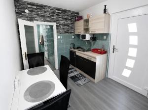 a small kitchen with a white table and chairs in it at Apartma B & O in Idrija