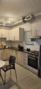 a kitchen with a stove and a chair and a table at Astros Lodge in Cape Town +59 photos