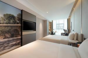 a hotel room with a bed and a flat screen tv at Atour Hotel Yan'an Luyi Park in Yan'an +31 photos