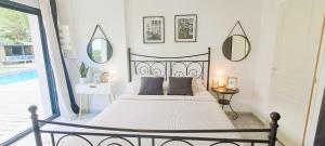 a bedroom with a bed and a large window at Jolie villa avec piscine chauffée proche du lac in Sanguinet +41 photos