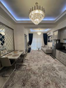 a living room with a chandelier and a dining room at Gardence Residence Suite in Tashkent