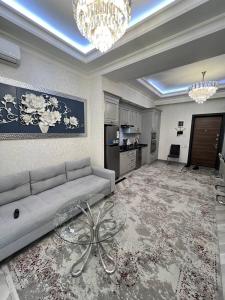 a large living room with a couch and a chandelier at Gardence Residence Suite in Tashkent +29 photos