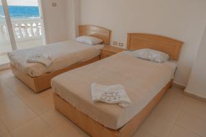 zwei Betten in einem Zimmer mit Meerblick in der Unterkunft Dahab Hotel in Dahab