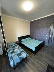 a room with two beds in it with a lamp at Отель Переулок средний 16 in Kropyvnytskyi