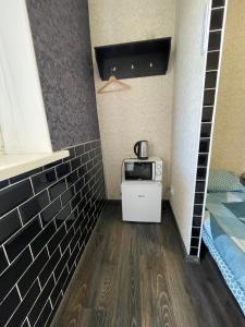 a small room with a microwave and a bed at Отель Переулок средний 16 in Kropyvnytskyi
