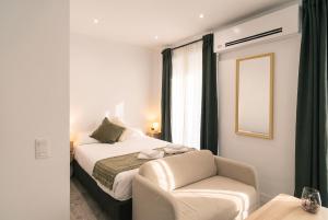 a bedroom with a bed and a chair and a mirror at InsideHome Ciudad del Cine in Valladolid