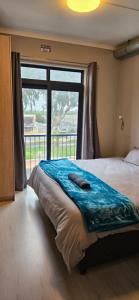 a bedroom with a large bed with a large window at Astros Lodge in Cape Town